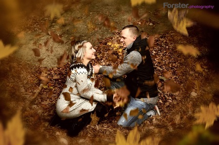 Junges Paar schaut sich in die Augen beim Fotoshooting im Herbstwald